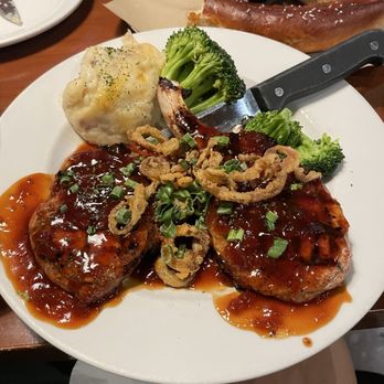Brick House Tavern + Tap signature dishes Drunken Chops (bourbon-glazed pork chops), Prosciutto-Wrapped Meatloaf, Crispy Duck Wings, Southern Fried Chicken Sandwich, various shareable snacks.